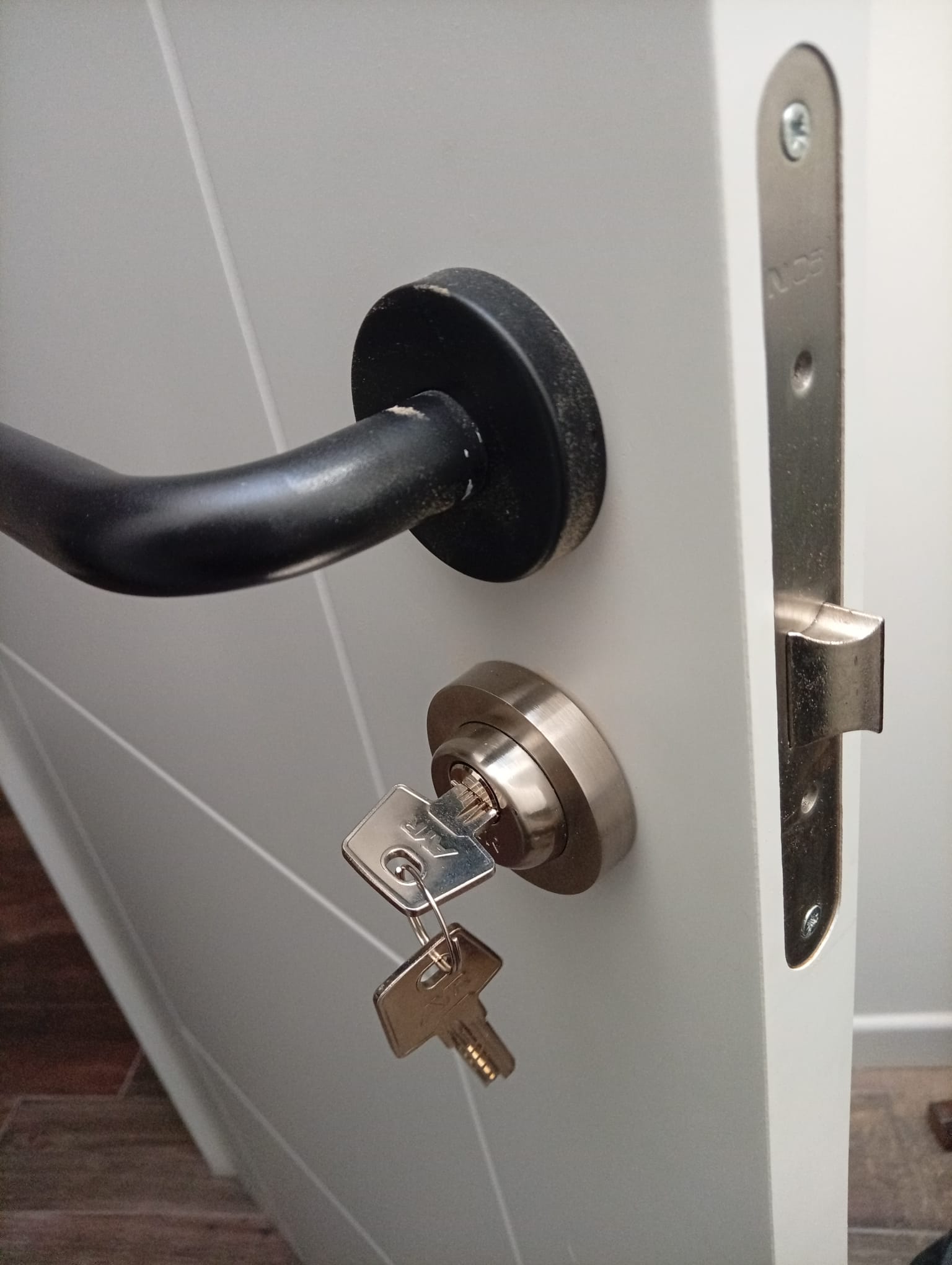 Instalación de cerradura de seguridad con llave en puerta blanca Madrid